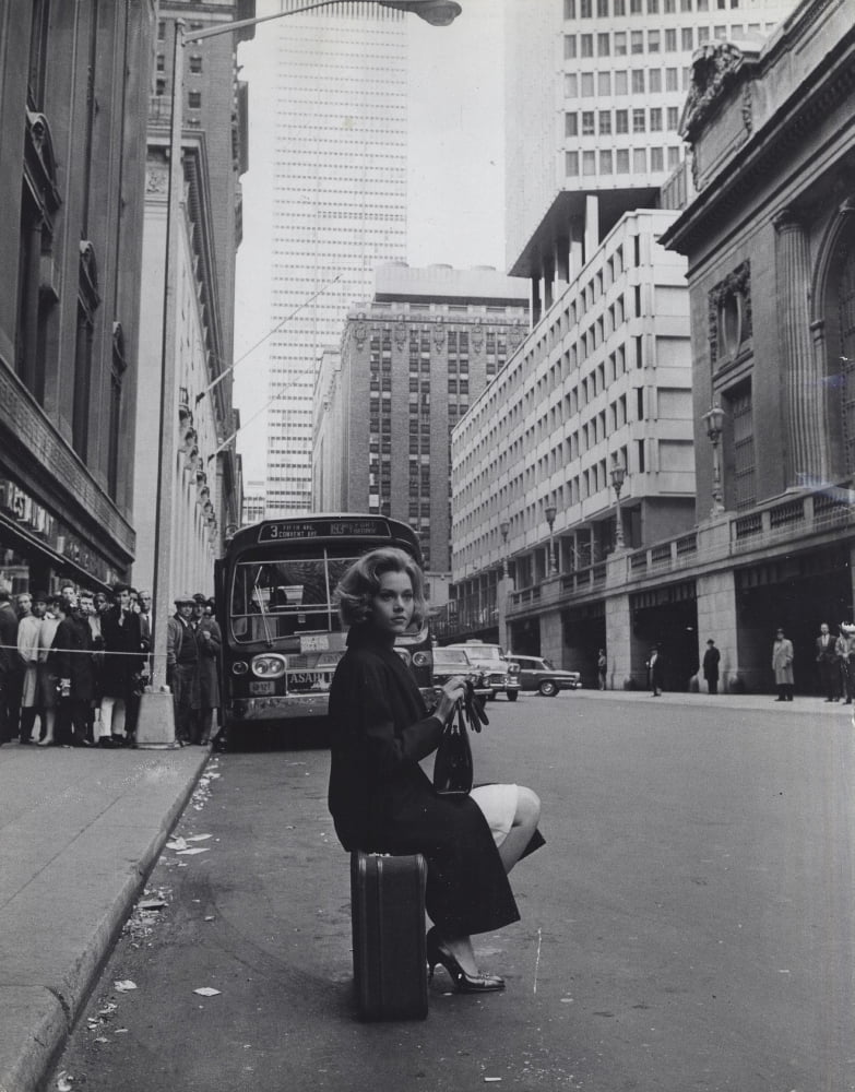 Jane Fonda sitting on a suitcase on a city street photo print