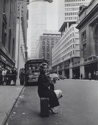 Jane Fonda sitting on a suitcase on a city street photo print