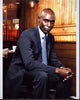 Lance Reddick sitting in a gray pinstripe suit photo print