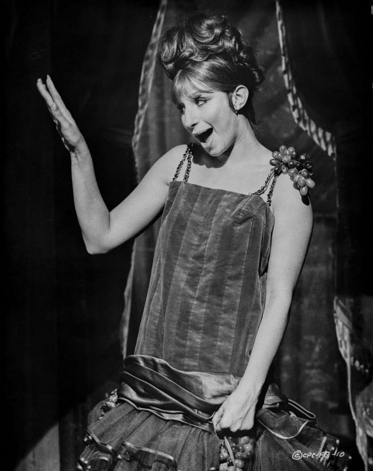 Barbra Streisand waving her hand in an elegant black dress photo print.