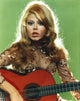 Charo playing guitar photo print on gray background.