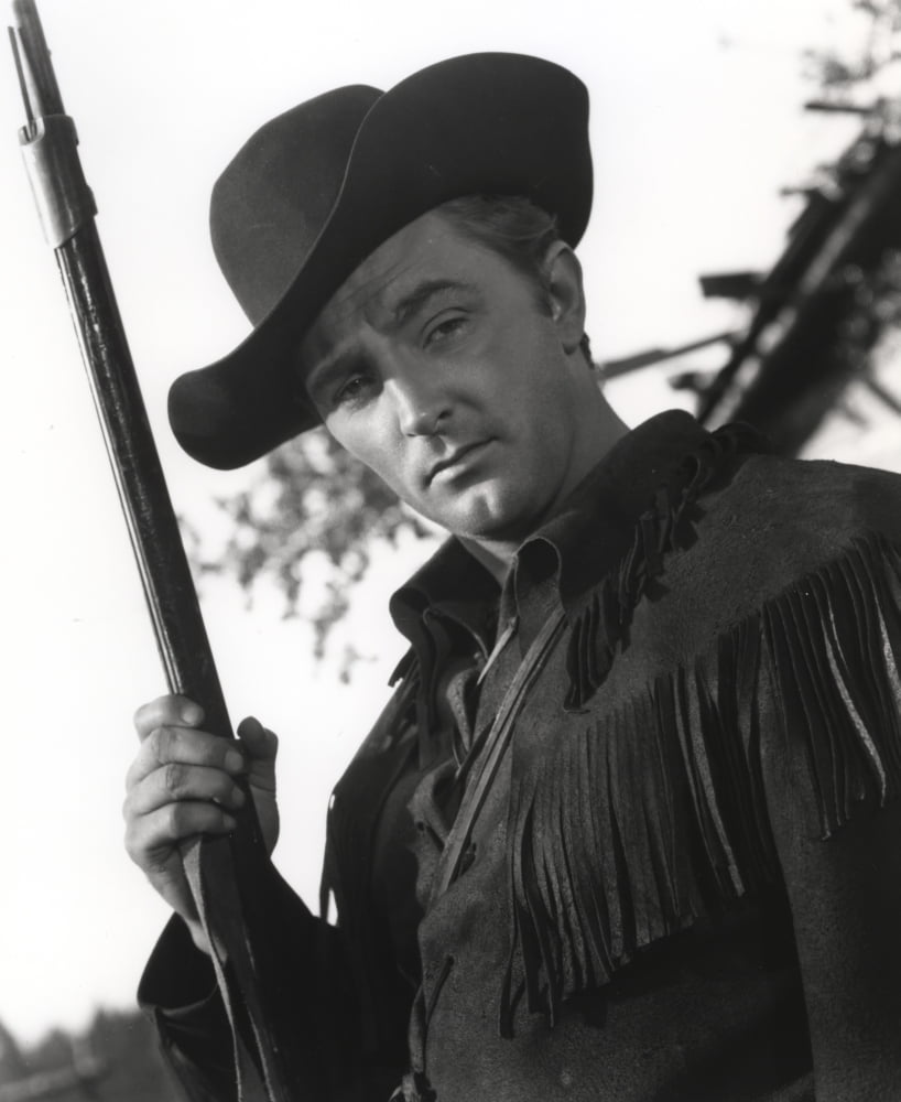 Film still featuring Robert Mitchum as a cowboy in a classic Western setting.