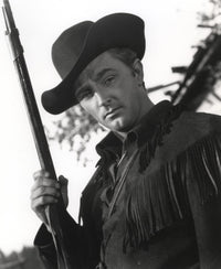 Film still featuring Robert Mitchum as a cowboy in a classic Western setting.