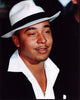 Lou Bega photo print in white fedora and unbuttoned shirt.