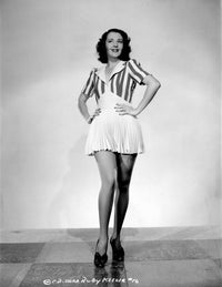 Ruby Keeler vintage photo print in printed dress with hands on waist.