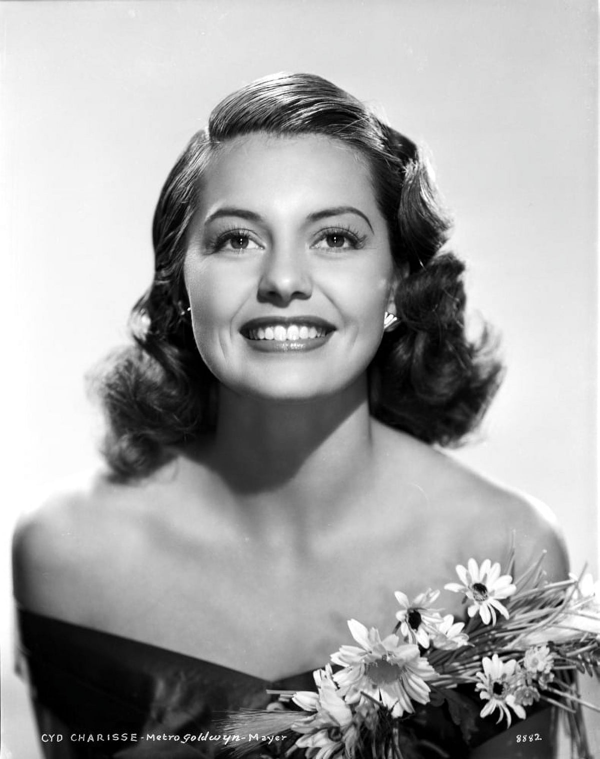 Cyd Charisse smiling in a black dress with flowers photo print.