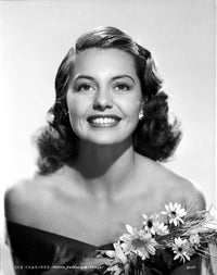 Cyd Charisse smiling in a black dress with flowers photo print.