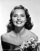Cyd Charisse smiling in a black dress with flowers photo print.
