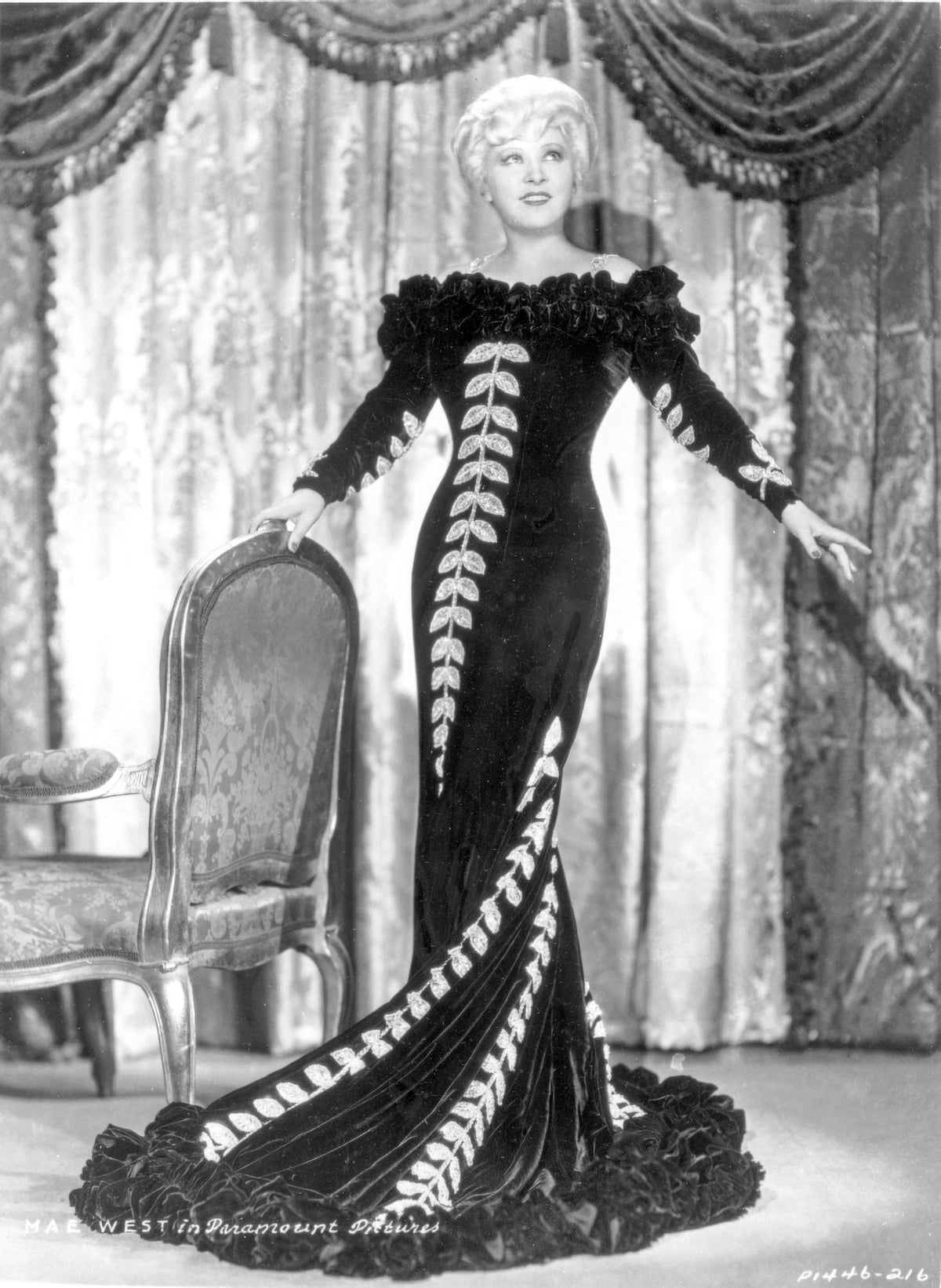 Mae West standing in black long gown photo print