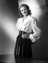 Ingrid Bergman photo print in long sleeve blouse with hands on waist.