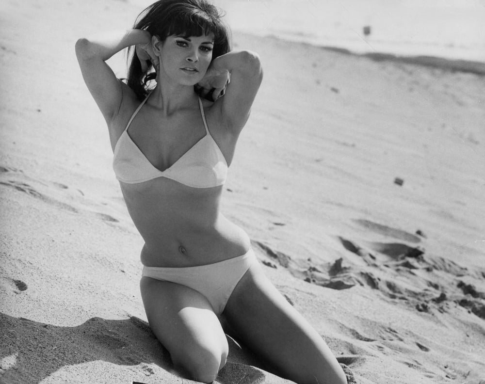 Raquel Welch posing in a bikini on the beach photo print.