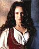 Madeleine Stowe elegant photo print in white dress with red vest.