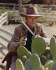 Chuck Connors vintage photo print holding weapon in brown coat.