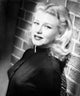 Photo print of Ginger Rogers leaning on a brick wall, classic Hollywood art.