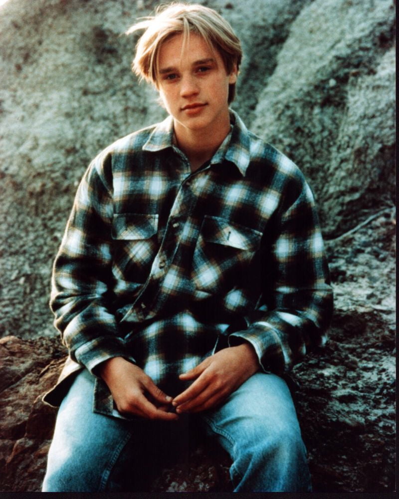 Devon Sawa sitting on rock in plaid shirt photo print