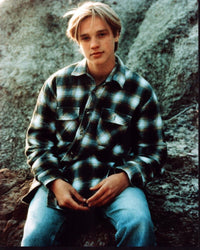 Devon Sawa sitting on rock in plaid shirt photo print