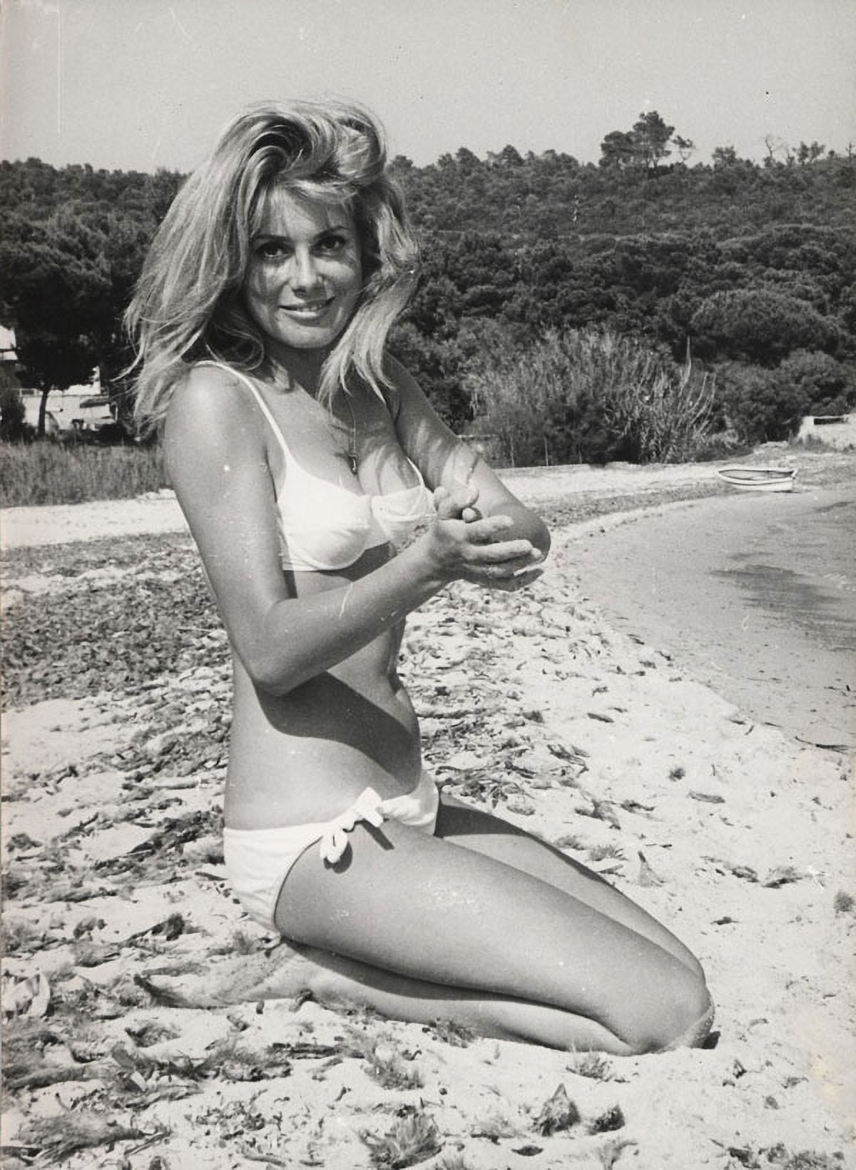 Catherine Deneuve kneeling on the beach photo print
