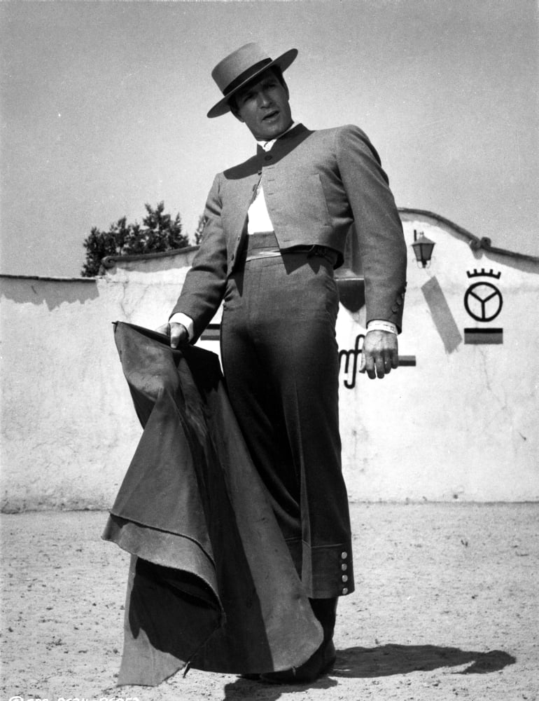Film still photo print of Hugh O'Brian with a matador's cape outdoors.