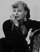 Greta Garbo photo print leaning on chair in black outfit.