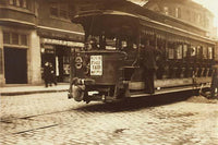 Young boy riding on the back of a trolley car poster print.