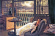 A young woman in a lace dress reclining on a couch with a stormy background - Poster Print by James Tissot.