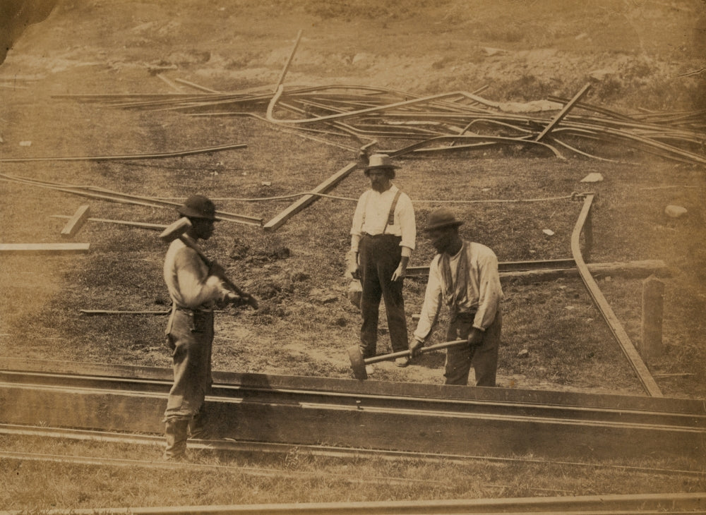 Two railroad construction workers hammering tracks poster print.