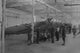 Airplanes being assembled in a factory under the watchful eye of a soldier poster print.
