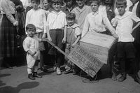 Toddler holding a Soap Box Derby vehicle surrounded by friends poster print.
