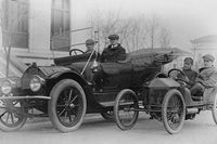 Poster print of two men in a large auto with two men in a miniature auto.