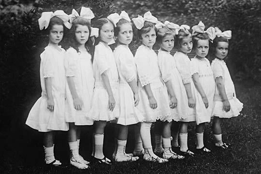 Poster print of seven kindergartners in white dresses arranged from largest to smallest.