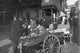 Banana Vendor Sells from Wooden Wheeled Cart Poster Print by Byron, colorful market scene artwork.