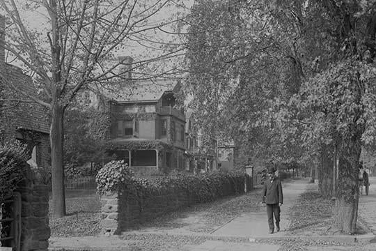 Poster print of a man walking down a tree-lined street in Germantown.