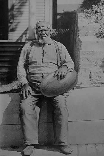 Old African American man holding a large watermelon poster print.