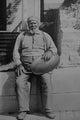Old African American man holding a large watermelon poster print.