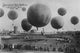 Multiple Balloons Take Off in a Berlin Air Race Poster Print showcasing colorful balloons in the sky.