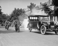 Police on Motorcycles Trailing Car with Smoke Poster Print