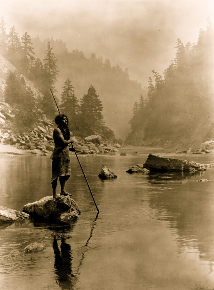 Hupa Man with Spear Poster Print featuring a man on a rock with foggy mountains in the background.