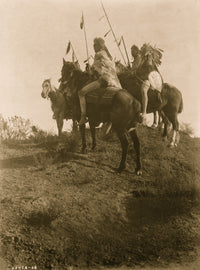 Four Crow men on horseback holding feathered spears poster print