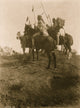 Four Crow men on horseback holding feathered spears poster print