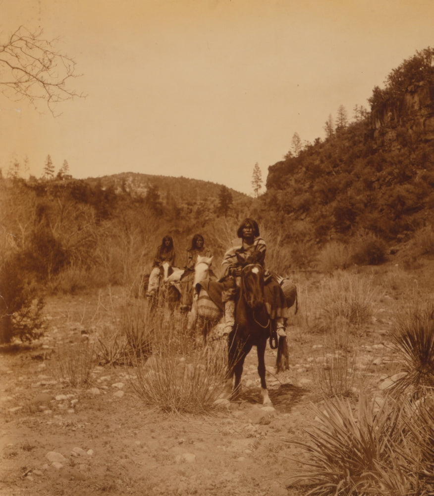 Three Apache people riding pack horses along rocky terrain poster print.