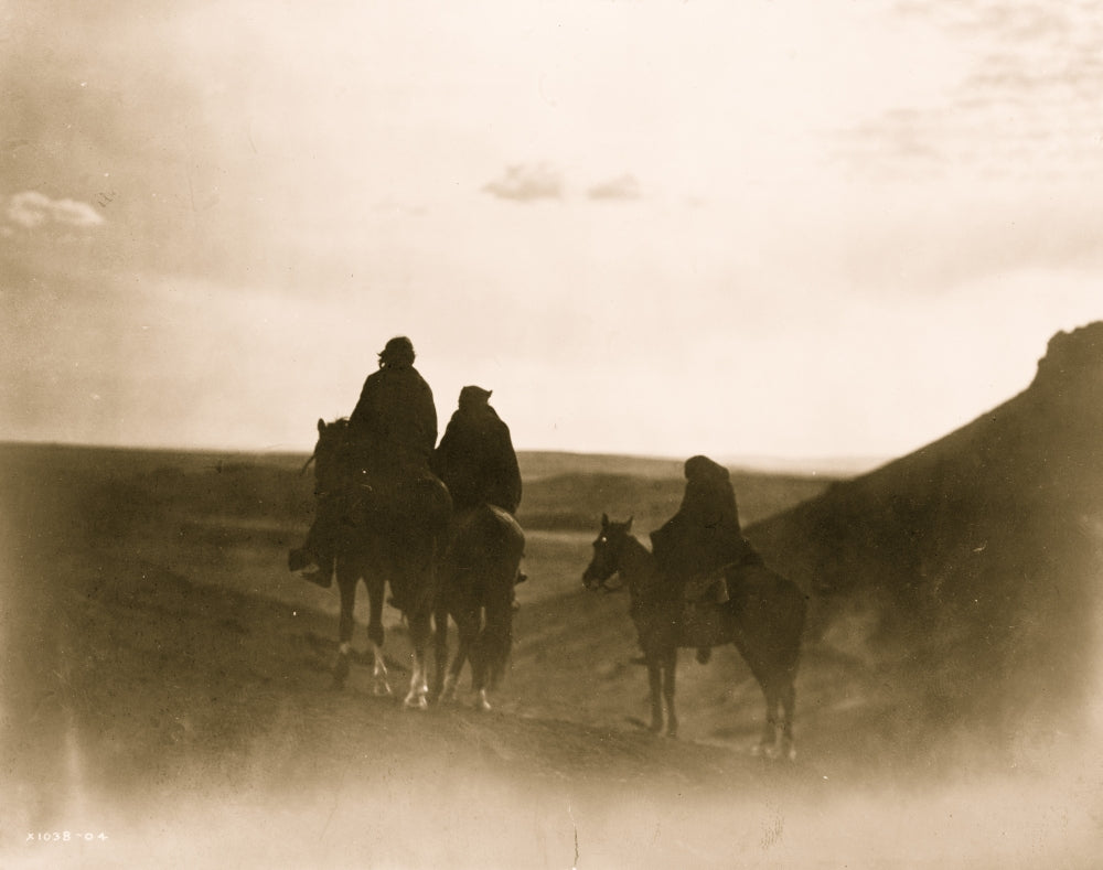 Three Navaho Indians on horseback silhouetted against black buttes in evening light poster print