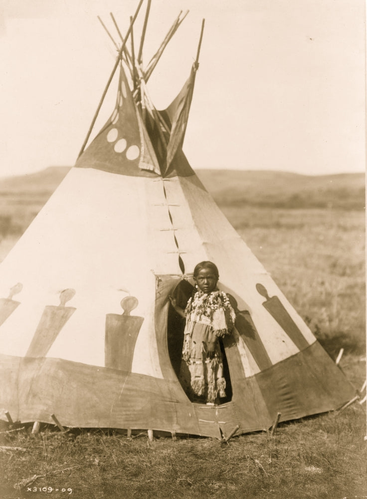 Piegan girl wearing beaded buckskin dress in doorway of tepee, Montana.