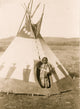 Piegan girl wearing beaded buckskin dress in doorway of tepee, Montana.