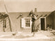 Tewa woman winnowing wheat in front of pueblo building poster print.