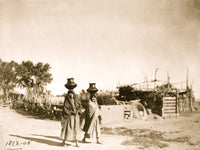 Two Pueblo women carrying jugs on their heads in a scenic desert landscape poster print.