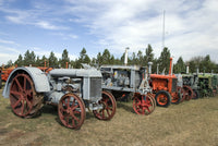 Old tractors along the road poster print showcasing rustic charm and Montana landscapes.