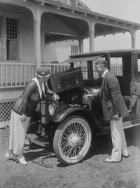 Man and woman inspecting car engine poster print