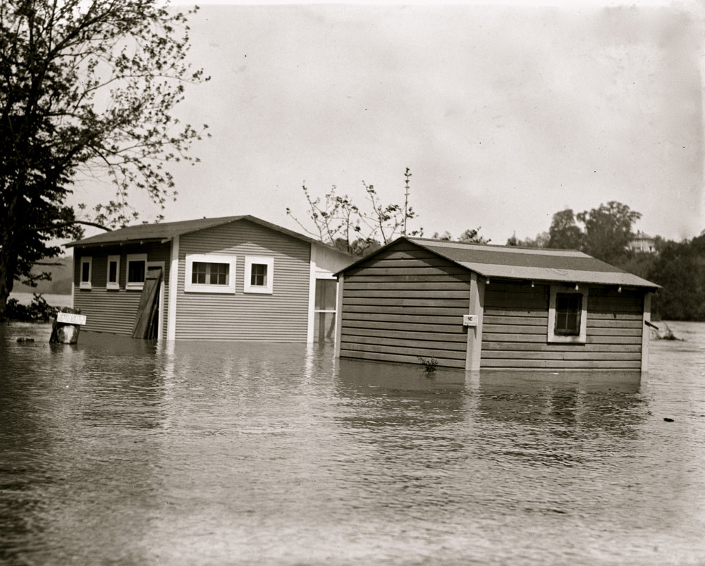 Floodwaters rise around a garage and home poster print