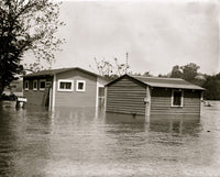 Floodwaters rise around a garage and home poster print