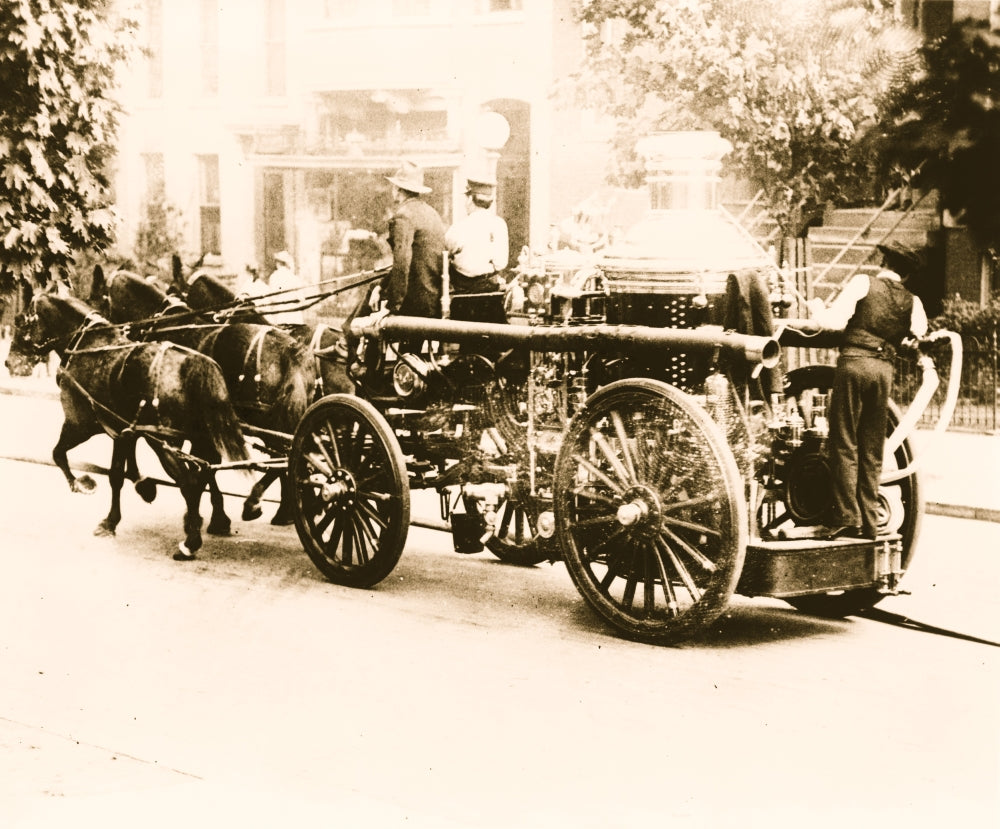 Three firemen on a fire engine drawn by three horses poster print.